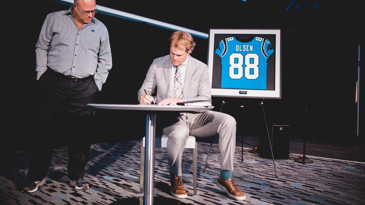 Carolina Panthers owner David Tepper and tight end Greg Olsen as he signs a one-day contract to retire as a Panther.