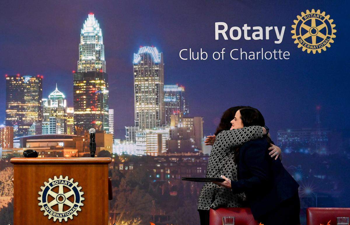 Kelly Garraghan Weeks, right, is hugged by Christine Cipriano, executive secretary for the Rotary Club of Charlotte, on Tuesday at the Fairfield Inn and Suites in uptown.
