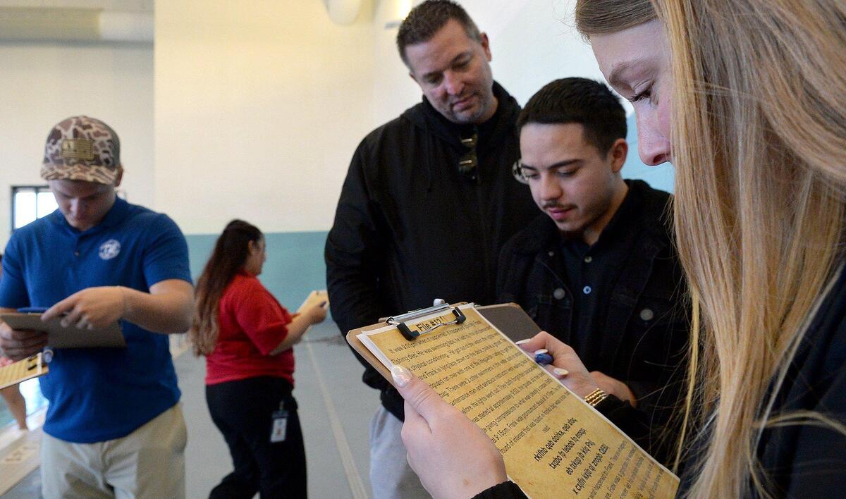 (L to R) Peyton Mincey, 21, Angelica Cabrera, 23, Michael Johnson, senior aquatic supervisor, Juan Gutierrez, 25 and Sabrina Husketh, 19, consult as they try to figure out the solution to a murder mystery event at the Eastway Regional Recreation Center. Saturday, Dec. 07, 2024.