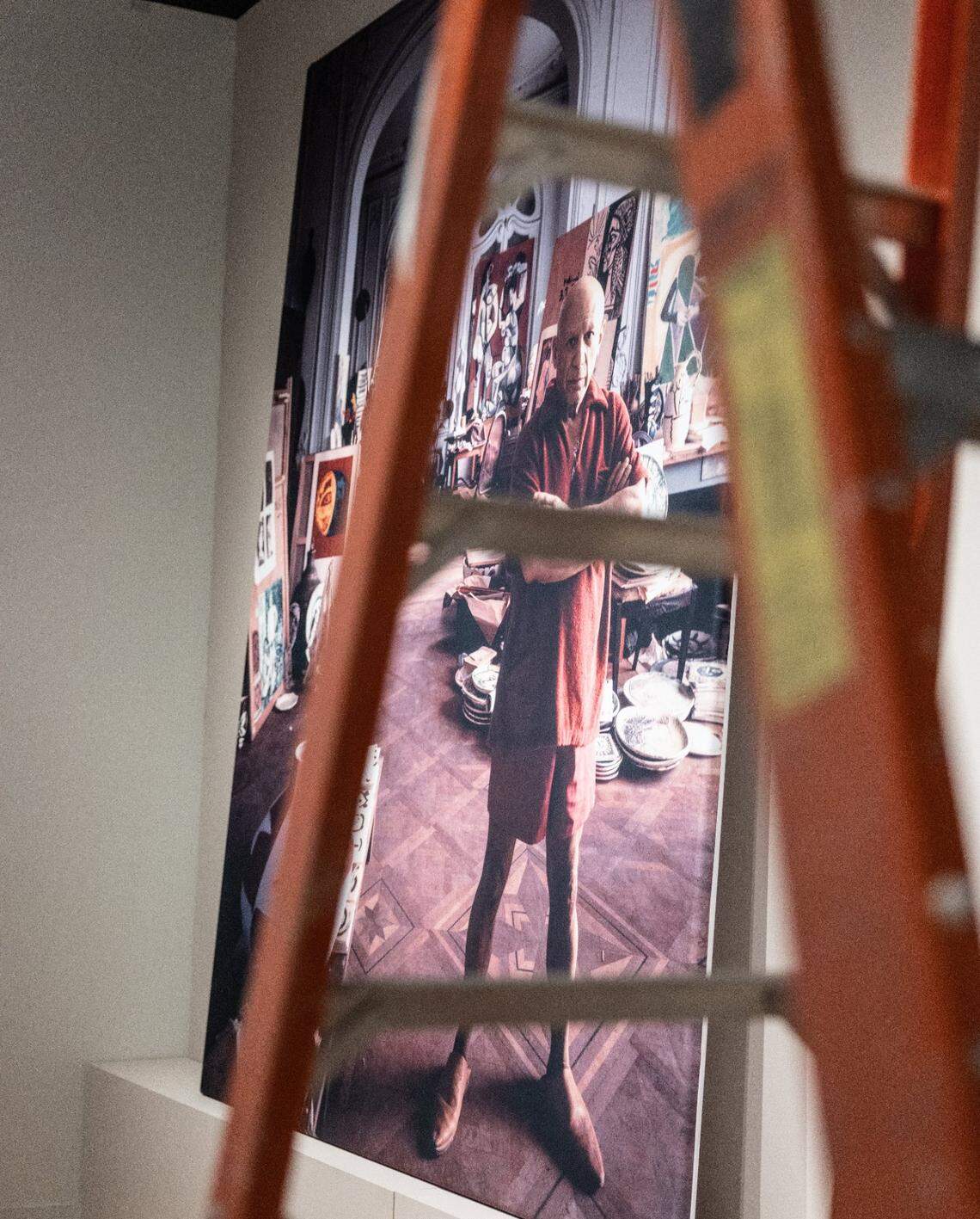 A portrait of Pablo Picasso sits behind a ladder during setup Jan. 31 for the “Picasso Landscapes: Out of Bounds” exhibition opening Feb. 11 at Mint Museum Uptown in Charlotte.