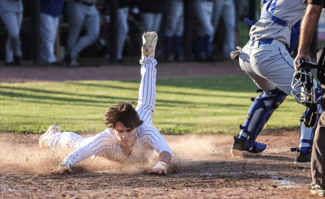 Cox Mill Chargers Cruise Ungaro slides into home against the Lake Norman Wildcats at Cox Mill High School in Concord, N.C., on Friday, April 12, 2024.