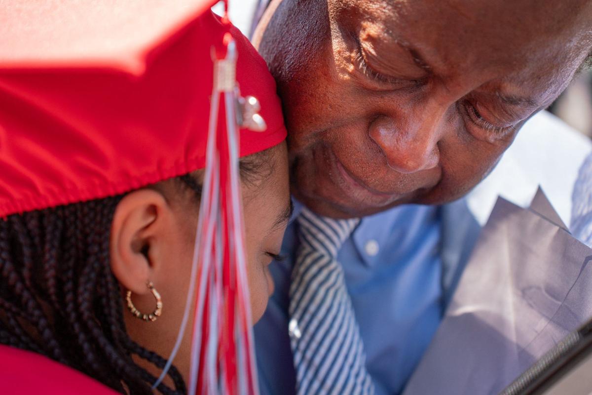 Carl Anderson Sr. gives his granddaughter Danielle Morris a hug after the the graduation ceremony at the Bojangles Coliseum in Charlotte on Monday, June 10, 2024.