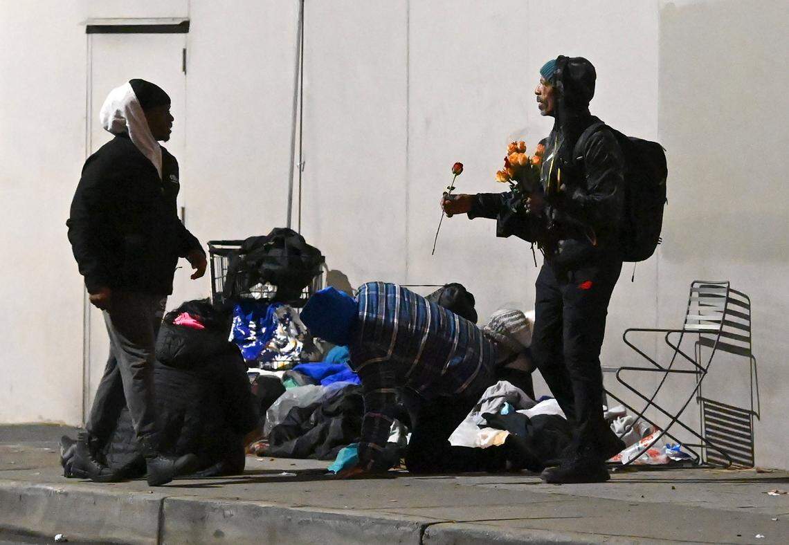 Chauncey Williams, right, offers a rose to Point-in-Time Count volunteer Jerald Collins, left, along Church St. in uptown Charlotte, NC., on Thursday, January 26, 2023. Volunteers took to the streets early Thursday to count Volunteers aim to get an accurate statistic of how many people in Charlotte are homeless, live in shelters or tents or cars, or otherwise have unstable housing arrangements.