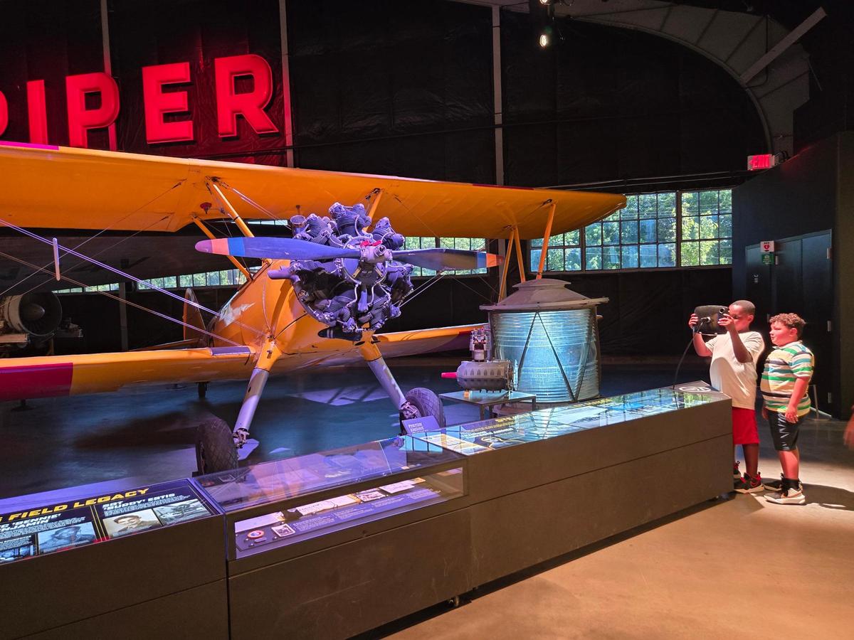 Campers from T. Jeffers Community Center learn about the history of Stearman biplane, used to train World War II pilots.