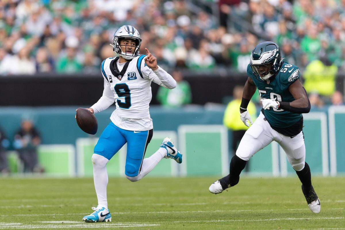 Dec 8, 2024; Philadelphia, Pennsylvania, USA;  Carolina Panthers quarterback Bryce Young (9) runs with the ball past Philadelphia Eagles linebacker Jalyx Hunt (58) during the second quarter at Lincoln Financial Field. Mandatory Credit: Bill Streicher-Imagn Images