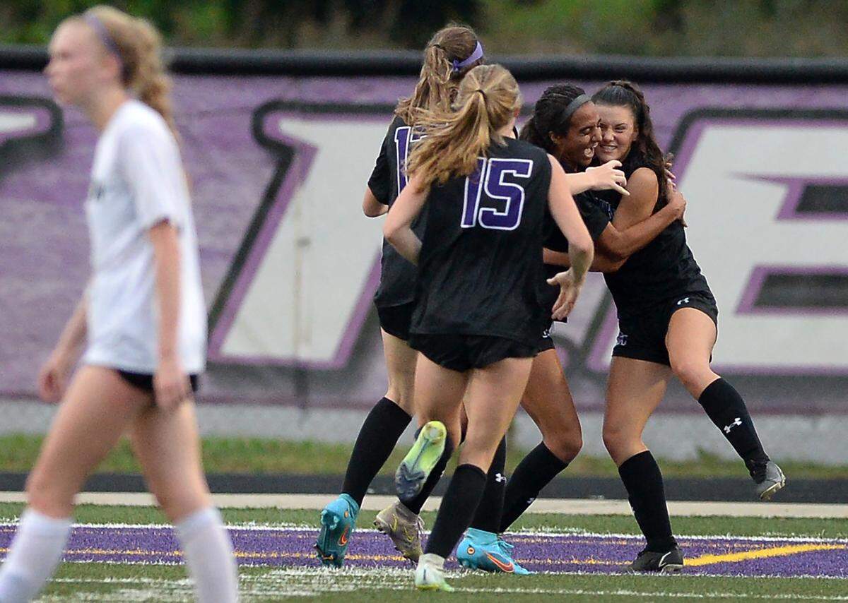 Members of the Ardrey Kell girls soccer team swarm Ally Casey, right, after she scored the team’s first goal against Hough in the state quarterfinals on Thursday, May 26, 2022. Ardrey Kell defeated Hough 2-1.