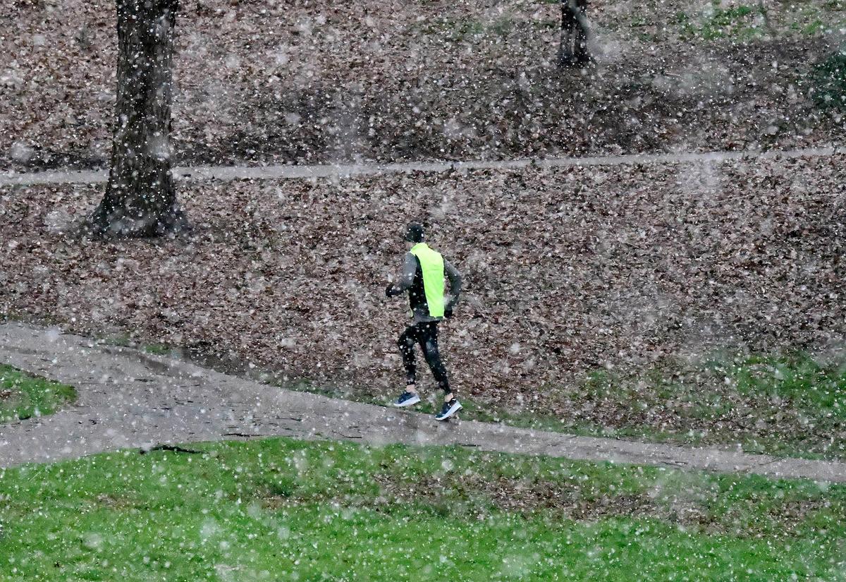 A jogger runs a path in Park Road Park during the snowfall in Charlotte, NC on Thursday, February 20, 2020.