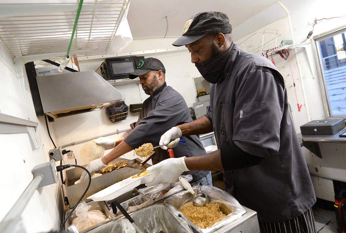 Chef Akil Courtney, left and executive chef Marco Boykin, right, prepare meals inside the Ve-Go Food Truck.