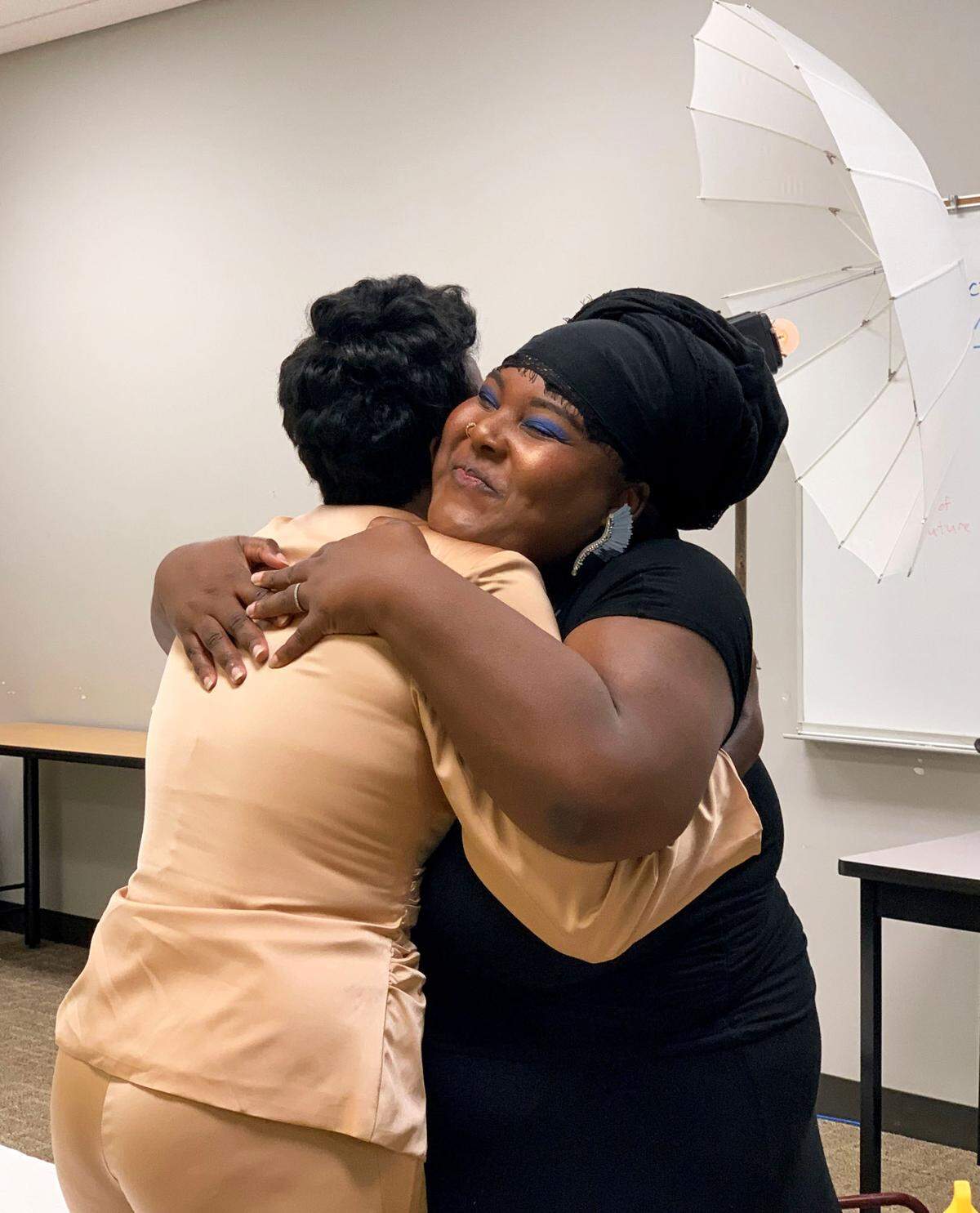 Hannah Hasan hugs Ohavia Phillips, one of the 50 Black women she interviewed for “I Am Queen Charlotte,” during a photo shoot for the book. Phillips will also host a hip-hop and R&B concert, Queens of the City, March 11 at Knight Theater.