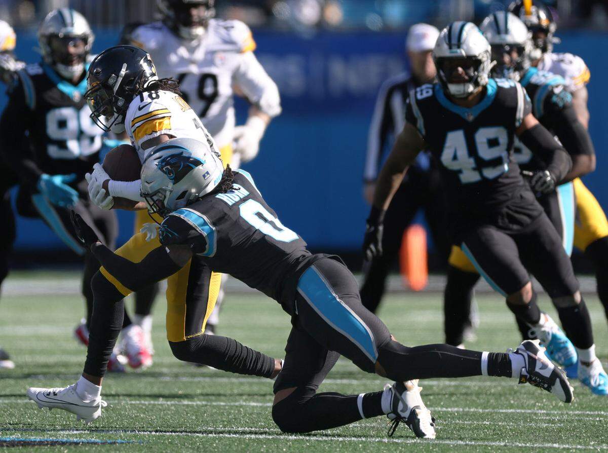Pittsburgh Steelers wide receiver Diontae Johnson (18), left, is tackled by Carolina Panthers cornerback Jaycee Horn (8) at the Bank of America Stadium in Charlotte, N.C., on Sunday, December 18, 2022.