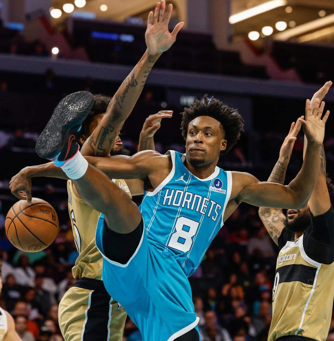 Hornets guard Collin Sexton loses control of the ball while driving to the basket during the game against the Wizards on Tuesday at Spectrum Center.