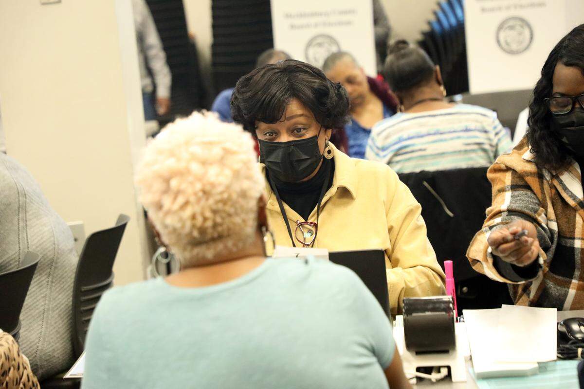 Election officials serve voters during early voting at the Allegra Westbrooks Regional Library in Charlotte, N.C. on October 17, 2024.