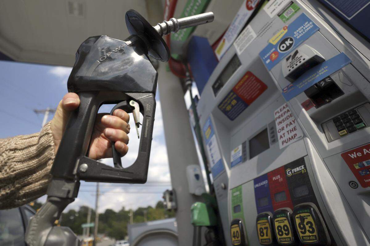 A woman pumps gas at a gas pump at a convenience store in 2019. 