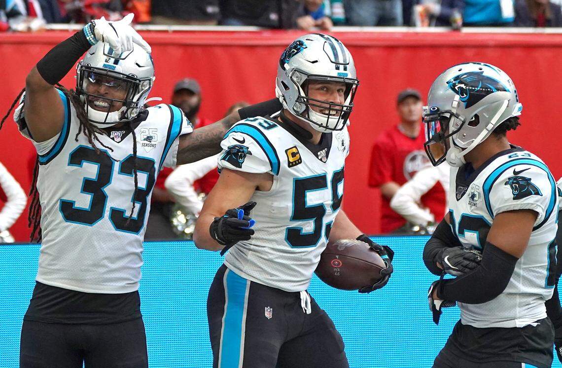 Carolina Panthers linebacker Luke Kuechly, center, is congratulated by teammates safety Tre Boston, left and cornerback Javien Elliott, right, after intercepting a pass by Tampa Bay Buccaneers quarterback James Winston during action at Tottenham Hotspur Stadium in London, England on Sunday, October 13, 2019. The Panthers defeated the Buccaneers 37-26.