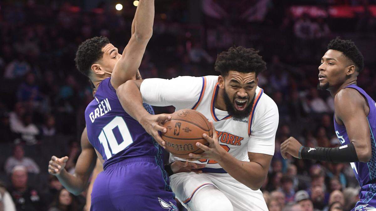 New York Knicks center Karl-Anthony Towns (32) drives past Charlotte Hornets guard Josh Green (10) during the first half at the Spectrum Center.