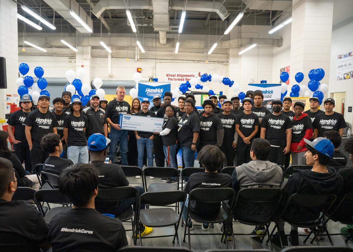 The “Hendrick! Get Set! Go!” initiative donated $25,000 to Harding University High School’s automotive technology program in Charlotte. Kyle Larson poses with the check with the students on Friday, Oct. 7, 2022.