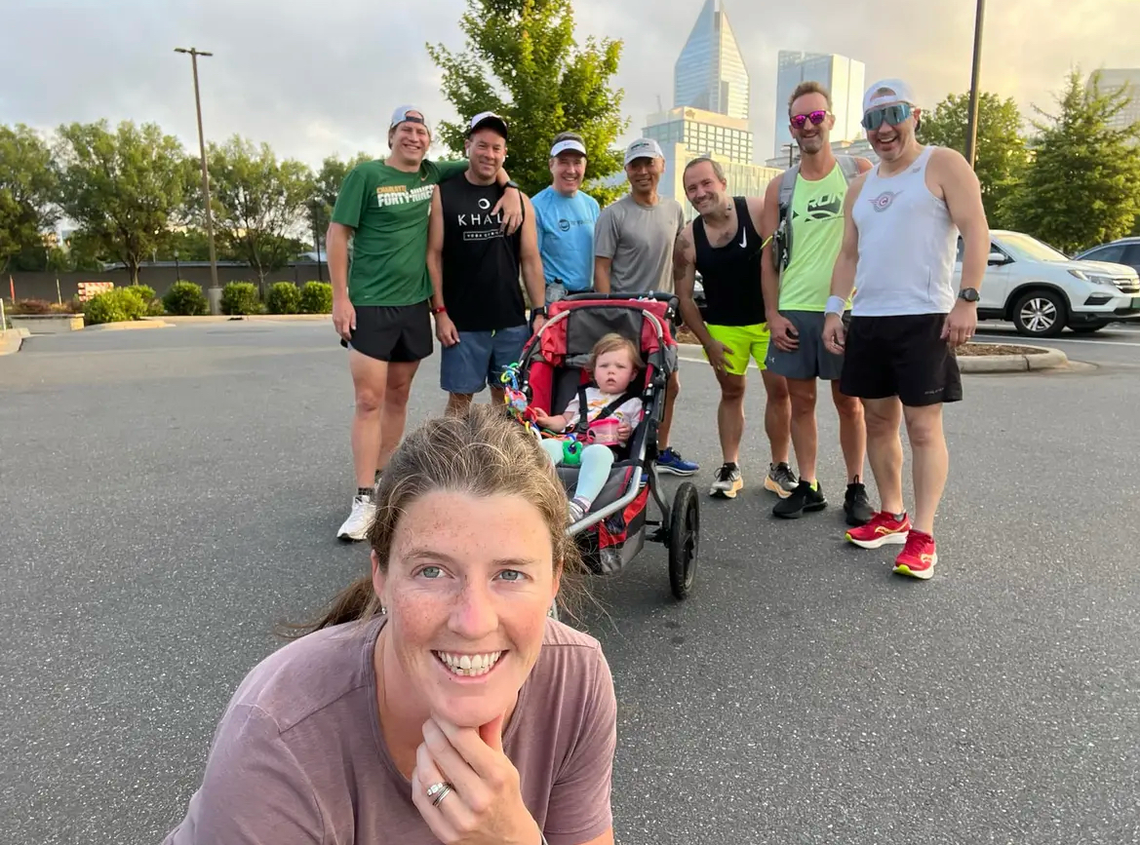 Erin Del Giudice takes a pre-run selfie with friends and her daughter Emma behind her in May 2023, a few months before the birth of son Noah.