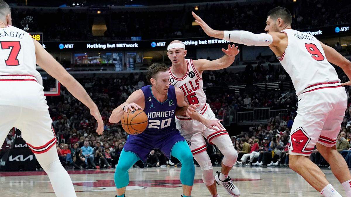 Charlotte Hornets forward Gordon Hayward (20) drives as Chicago Bulls guard Goran Dragic, left, center Nikola Vucevic, right, and guard Alex Caruso, rear, defend during the first half of an NBA basketball game in Chicago, Wednesday, Nov. 2, 2022. (AP Photo/Nam Y. Huh)