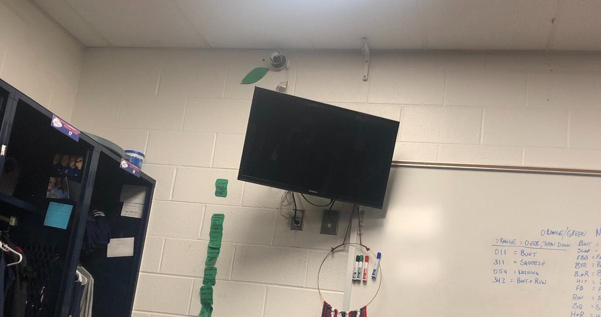 The camera, before it was removed, can be seen just above the TV and below the fluorescent light in this photo taken by a member of the Catawba College softball team.