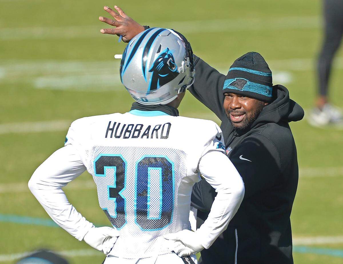 Carolina Panthers offensive coordinator Jeff Nixon, right, speaks with running back Chuba Hubbard, left, during practice on Wednesday, December 15, 2021.