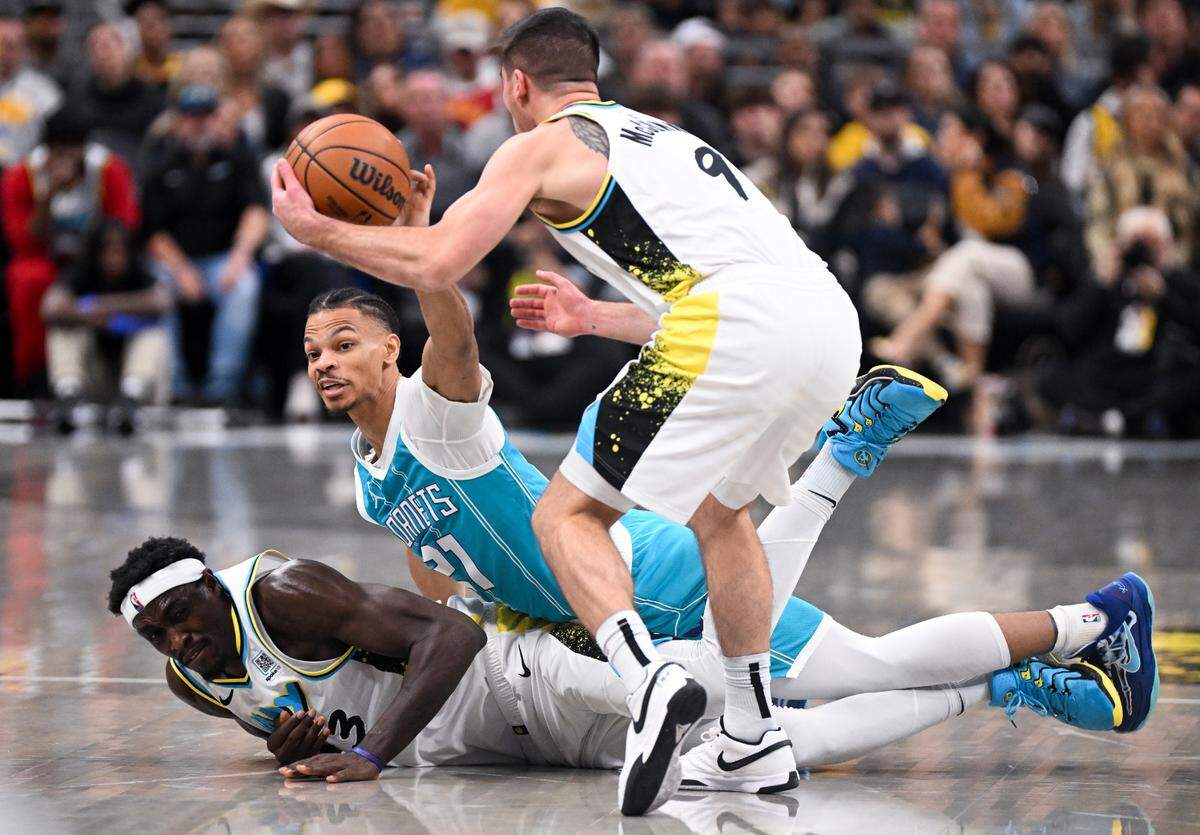 Dec 8, 2024; Indianapolis, Indiana, USA; Charlotte Hornets guard Isaiah Wong (21) tips a loose ball away from Indiana Pacers guard T.J. McConnell (9) during the first half at Gainbridge Fieldhouse.