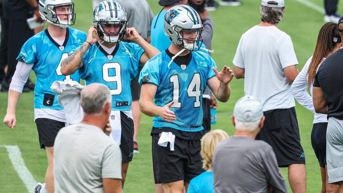 Panthers quarterbacks Matt Corral, second from left, and Sam Darnold, center, walk on to the practice field during day two of mini camp on Wednesday, June 15, 2022 in Charlotte, NC.