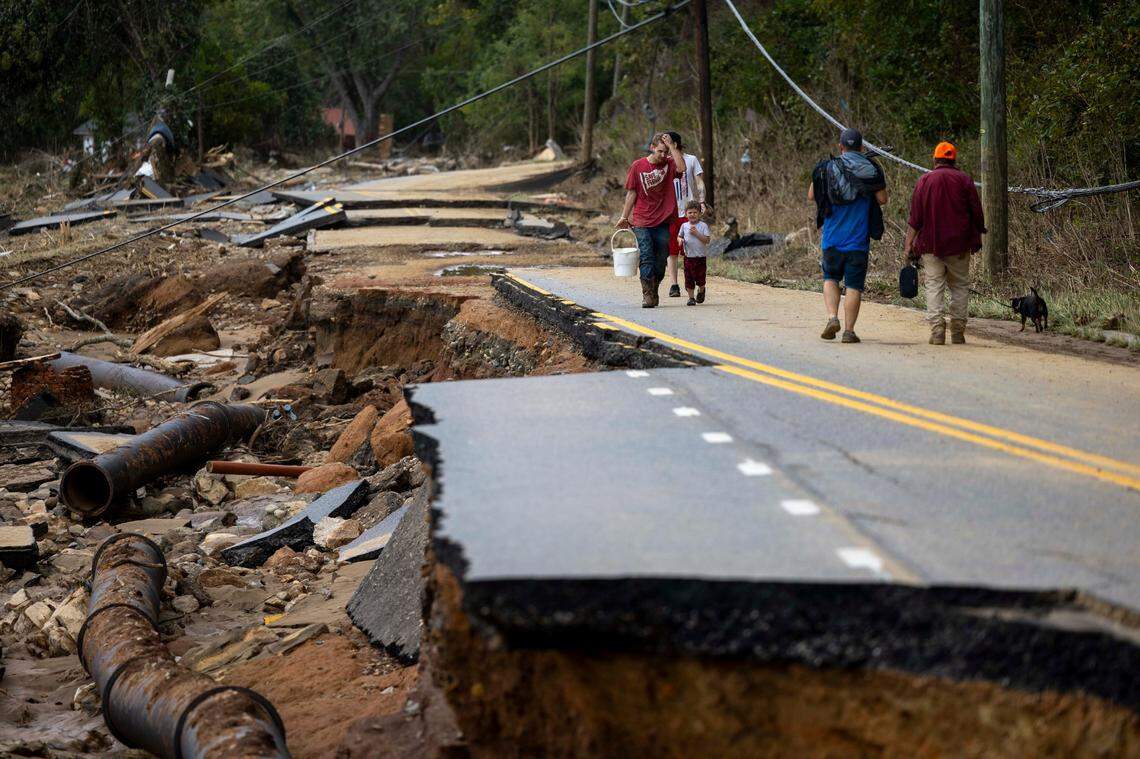 Swannanoa residents walk through devastating flood damage from the Swannanoa River on Sunday, Sept. 29, 2024. The remnants of Hurricane Helene caused widespread flooding, downed trees, and power outages in western North Carolina.