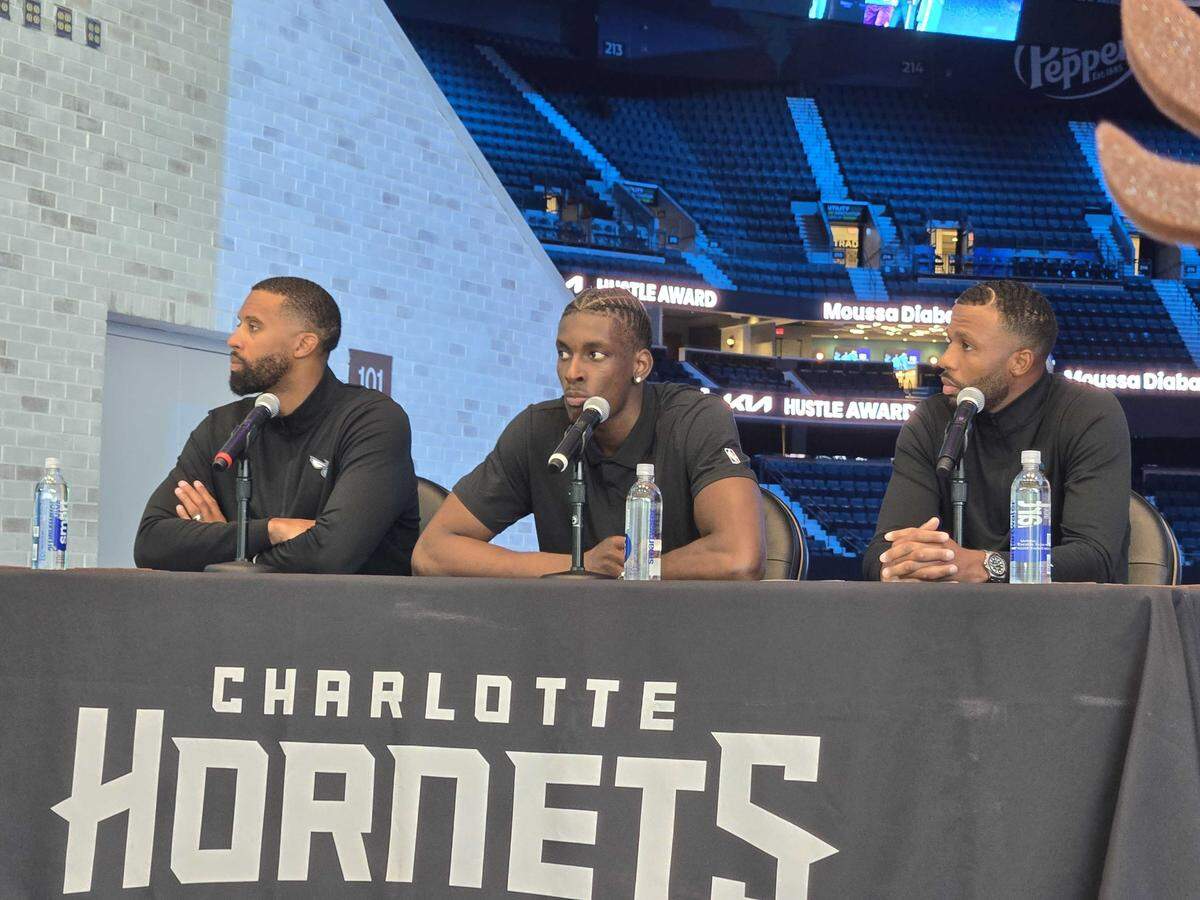 Charlotte Hornets F/C Moussa Diabaté (center) is flanked by Hornets coach Charles Peterson (left) and Hornets president of basketball operations Jeff Peterson as .Diabaté is honored for winning 2025-25 Kia Hustle Award.