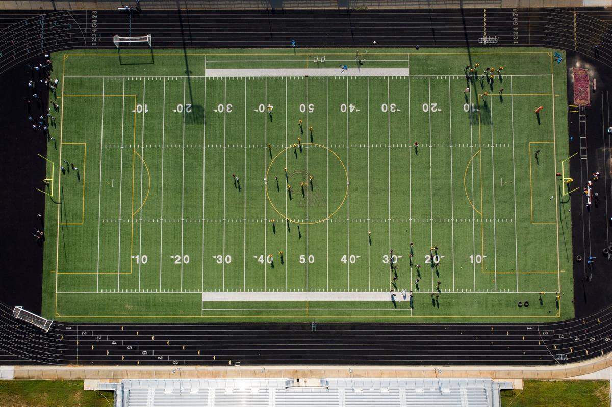 Football players run drills during practice at West Charlotte High School in Charlotte, N.C., on Thursday, Aug. 4, 2022. Lions head coach Sam Greiner was suspended July 26.