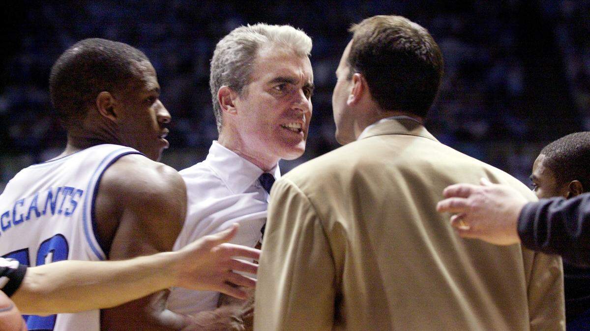 UNC head coach Matt Doherty confronts Duke assistant coach Chris Collins (right) as UNC’s Rashad McCants (left) tries to restrain Doherty during an altercation in the second half of 2003’s game at the Dean Smith Center in Chapel Hill. Doherty had come on to the court to check on Raymond Felton, who was bleeding from the mouth after a physical play.