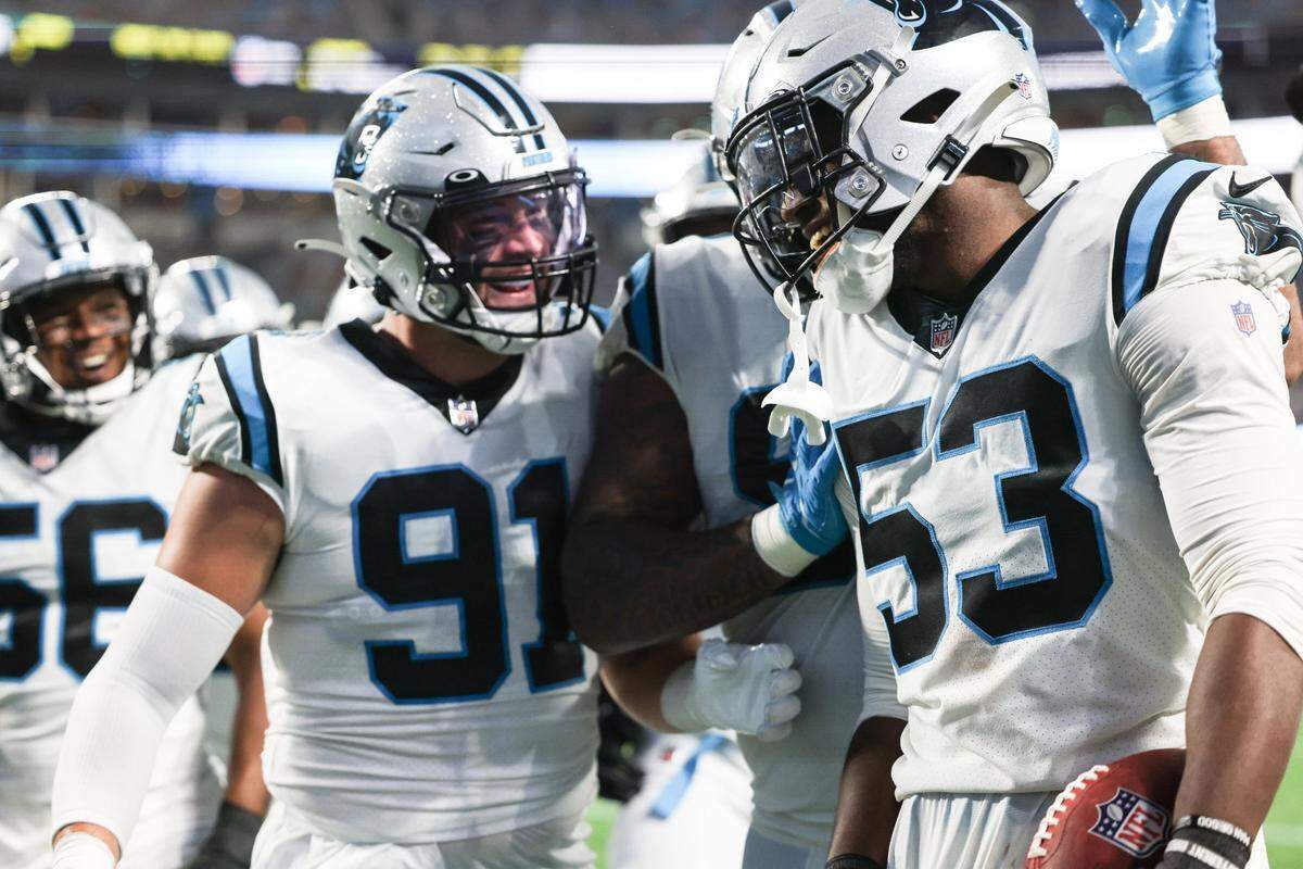 Carolina Panthers Brian Burns, right, celebrates an interception at the Bank of America Stadium in Charlotte, N.C., on Friday, August 27, 2021.