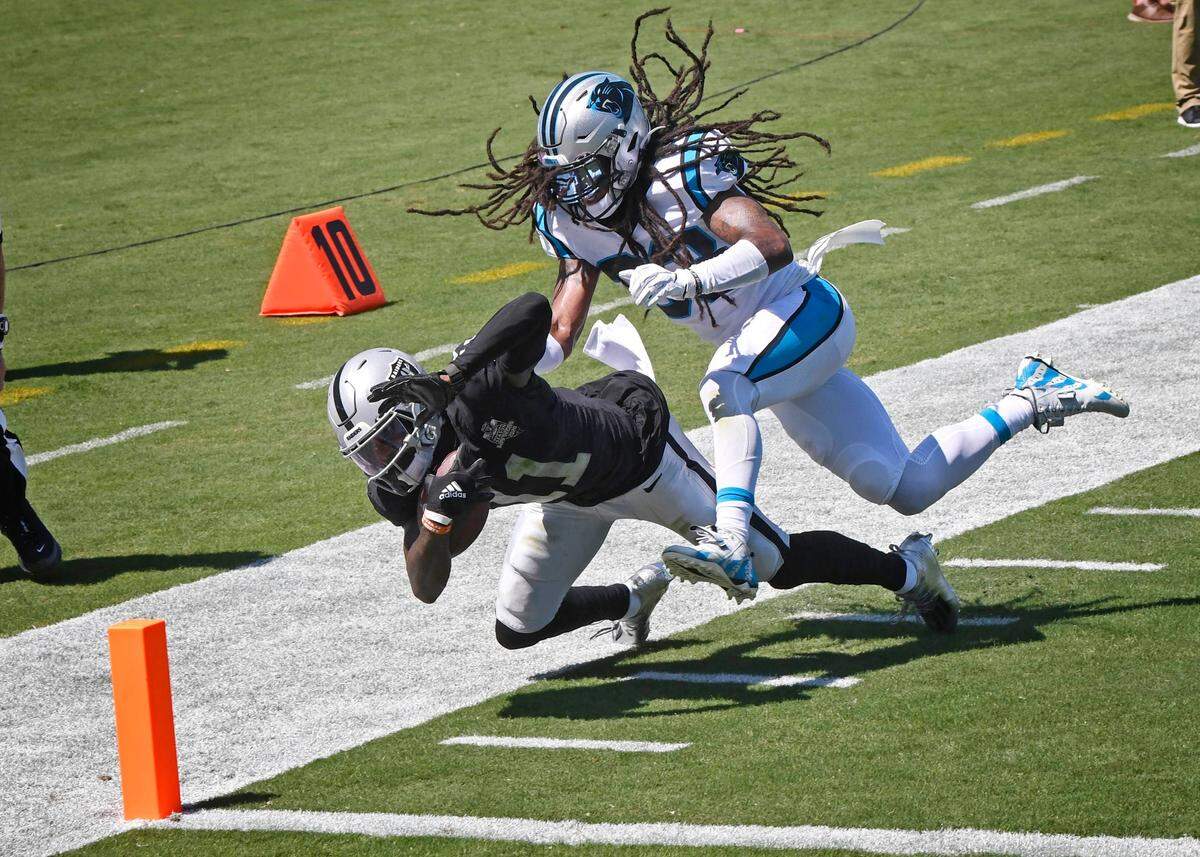 Las Vegas Raiders wide receiver Henry Ruggs III (11) stretches for the goal line but is knocked out of bounds by Carolina Panthers safety Tre Boston (33) during the first half in their opening game of the 2020 NFL season at Bank of America Stadium on Sunday, September 13, 2020.