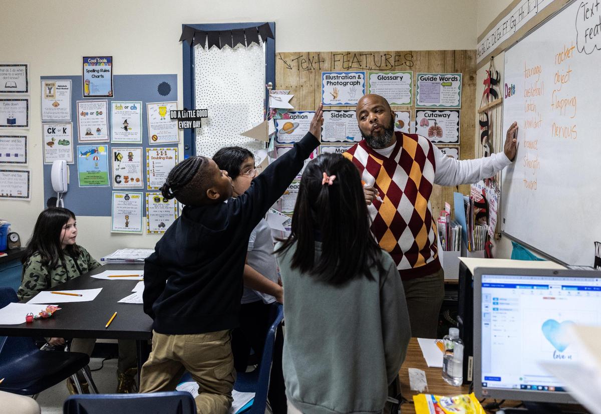 Troy Aikens tutors students on spelling at Joseph W. Grier Academy in Charlotte, N.C., on Thursday, March 9, 2023.