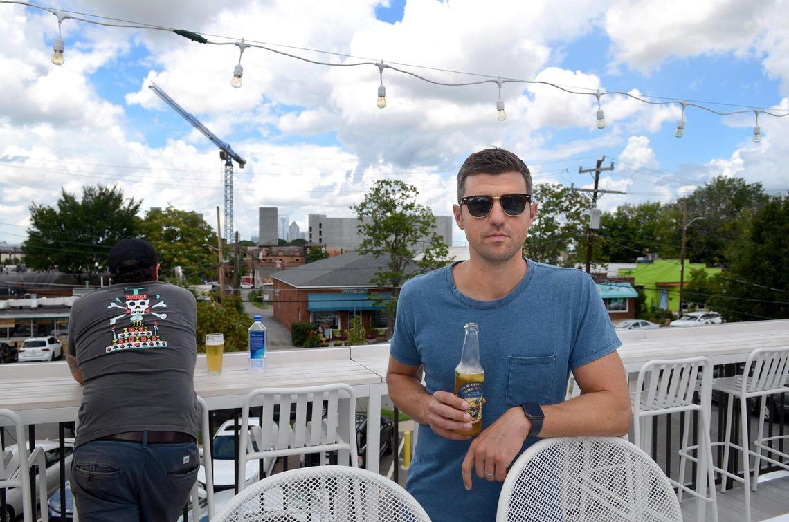 Burial Beer owner Doug Reiser poses on the rooftop bar at 1214 Thomas Ave., showing off the skyline view his brewery has lost.