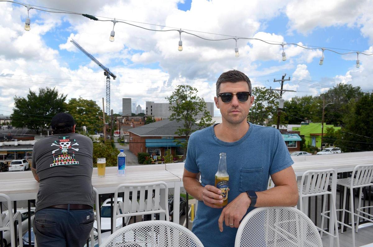 Burial Beer owner Doug Reiser poses on the rooftop bar at 1214 Thomas Ave., showing off the skyline view his brewery has lost.