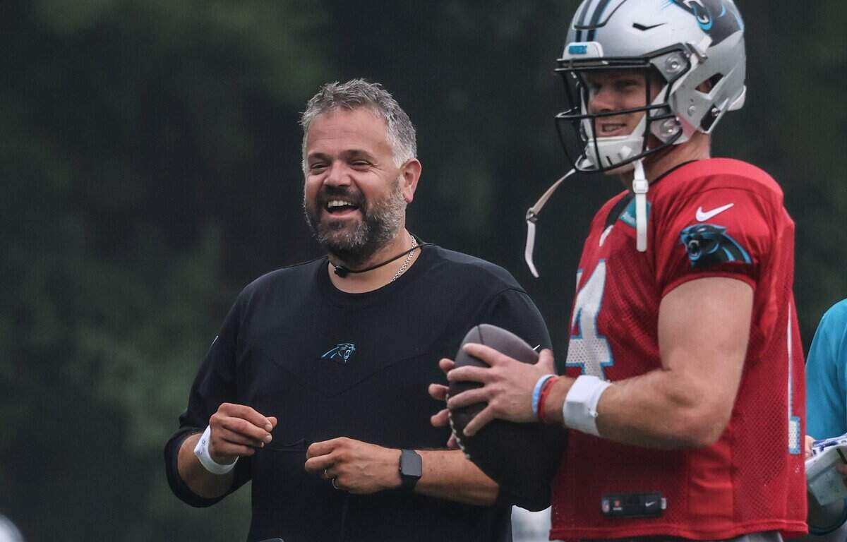 Carolina Panthers coach Matt Rhule, left, shares a laugh with Sam Darnold during a drill in August 2021.