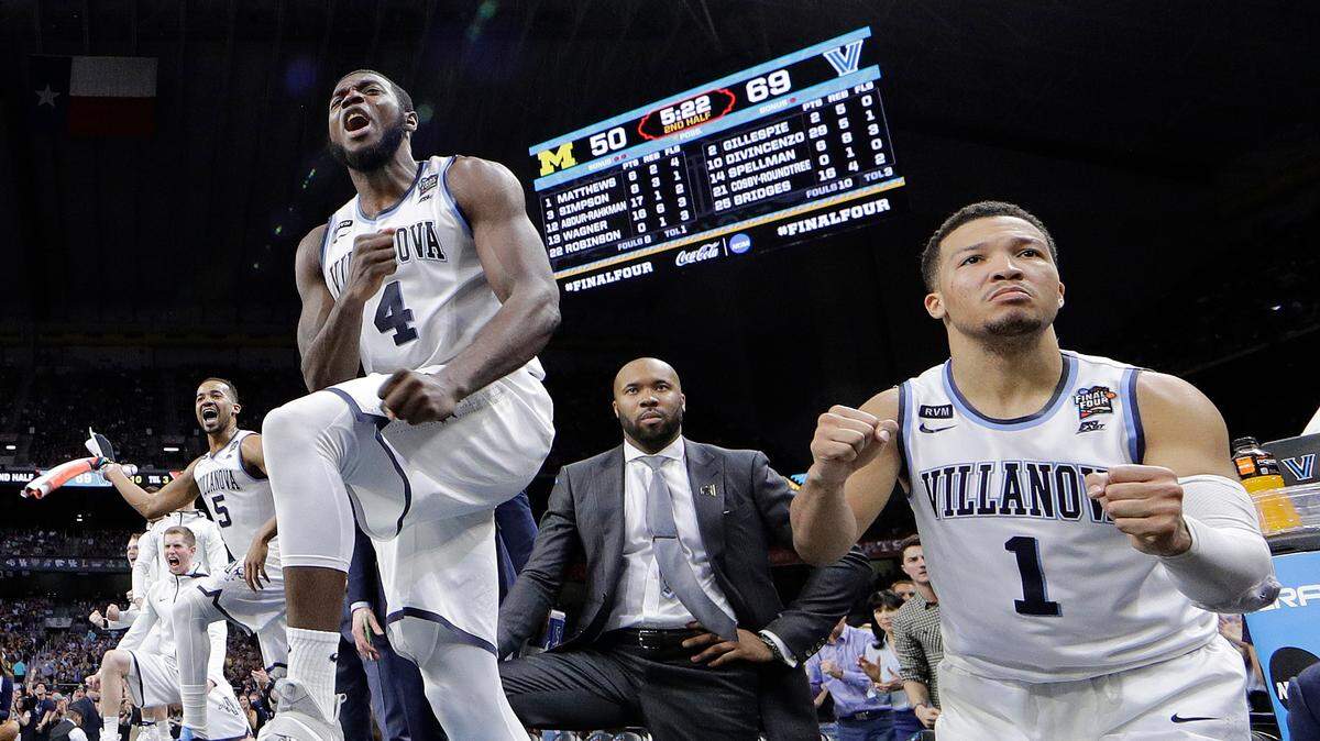 Villanova's Jalen Brunson (1), Eric Paschall (4) and players on Villanova bench react to a 3-point basket during the second half in the championship game of the Final Four NCAA college basketball tournament against Michigan, Monday, April 2, 2018, in San Antonio.