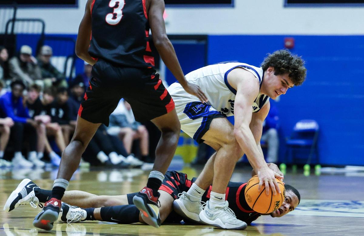 Lake Norman Wildcats Nick Arnold, front, grabs the ball from West Cabarrus Wolverines Jacob Warren at Lake Norman High School in Mooresville, N.C., on Tuesday, January 7, 2025.