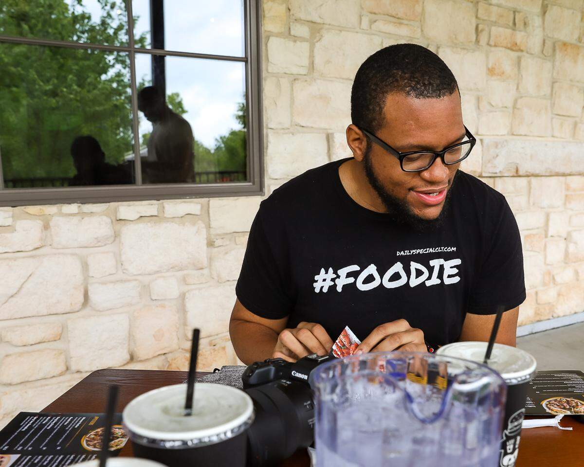 Cory Wilkins browses a menu for food and drink specials — his wheelhouse as @dailyspecialclt on Instagram.