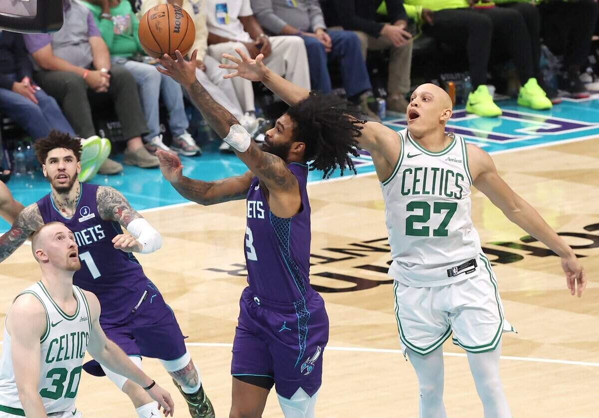 Charlotte Hornets guard Coby White, center, drives to the basket around Boston Celtics forward Jordan Walsh, right, during action at Spectrum Center in Charlotte, NC on Sunday, March 29, 2026. The Celtics defeated the Hornets 114-99.