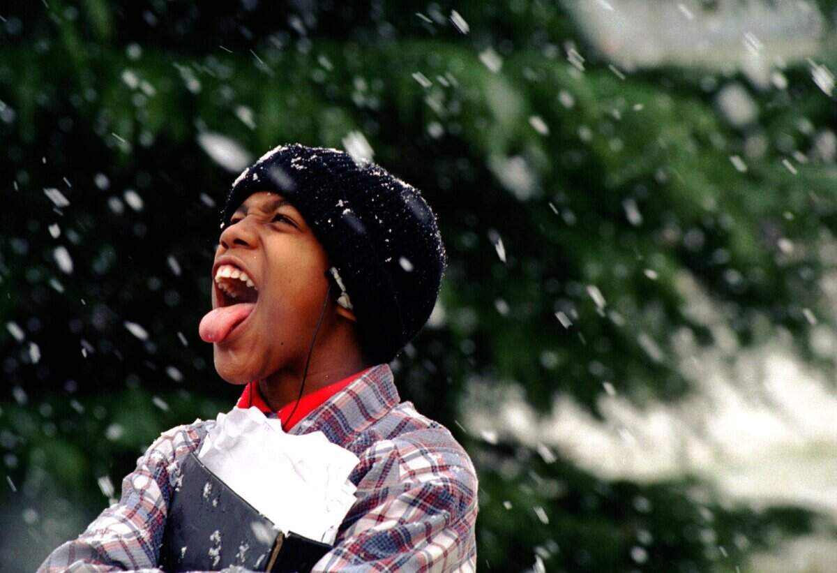 Tony Withrow, 13, a seventh-grader at Grier Junior High in Gastonia tries to catch a few snowflakes on his tongue on Jan. 24, 1995, while waiting for the school bus. Gaston County schools were among those that dismissed early because of the snowfall.