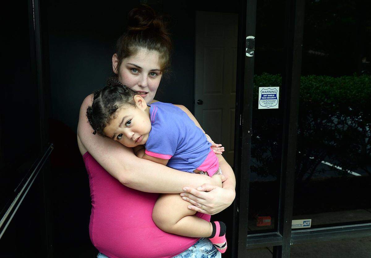 Katelen Harvey, 26, cradles her daughter Ahnadia Gregg, 22 months, at her boyfriend’s studio at 6636 E. W.T. Harris Blvd.Harvey and her boyfriend, Roy Gregg, 32, thought they had escaped the wrath of former Hurricane Florence, when she heard a loud thud on Sunday, Sept 16. A large tree had fallen on through the roof and destroyed their rental house in Charlotte.