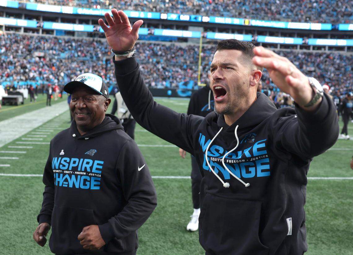 Carolina Panthers head coach Dave Canales, right, looks to motivate the fans more following the team’s 23-20 victory over the Tampa Bay Buccaneers on Dec. 21, 2025, at Bank of America Stadium in Charlotte.