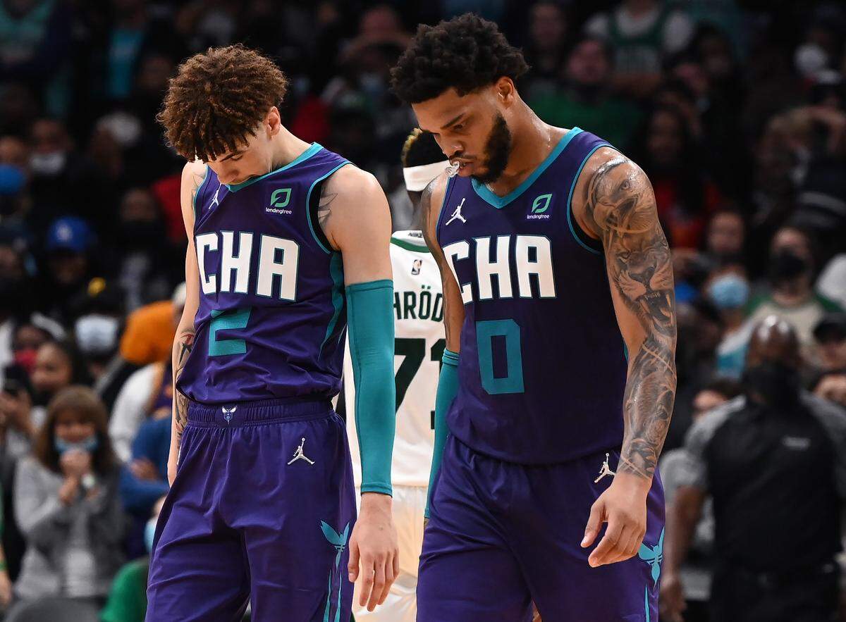 Charlotte Hornets guard LaMelo Ball, left, and forward Miles Bridges walk off the court frustrated after losing a lead over the Boston Celtics during fourth-quarter action at Spectrum Center in Charlotte, NC on Monday. The Hornets led by 12 points with 6:06 to go in regulation, but the Celtics defeated the Hornets 140-129 in overtime.