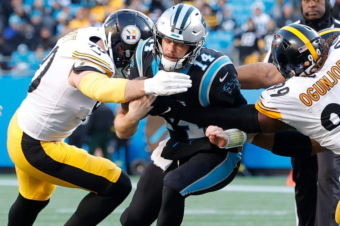 Carolina Panthers quarterback Sam Darnold (14) is stopped by Pittsburgh Steelers linebacker T.J. Watt (90) and Pittsburgh Steelers defensive tackle Larry Ogunjobi (99) during a game at Bank of America Stadium in Charlotte, N.C., Sunday, Dec. 18, 2022.