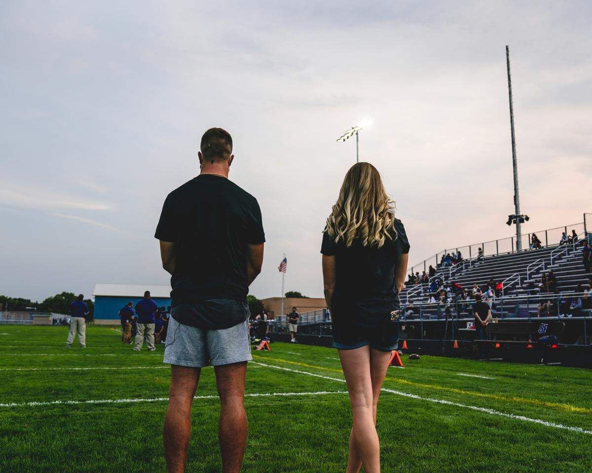 Carolina Panthers WR Adam Thielen, then of the Minnesota Vikings, and his wife, Caitlin, stare up at the newly built lights at Brooklyn Center High School in Brooklyn Center, Minnesota in 2021.