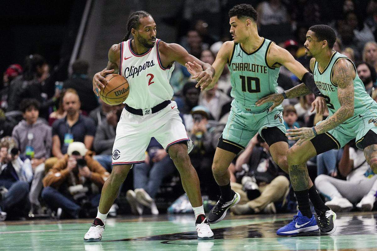 LA Clippers forward Kawhi Leonard (2) looks for an opening defended by Charlotte Hornets guard Josh Green (10) and guard DaQuan Jeffries (3) during the second quarter at Spectrum Center.