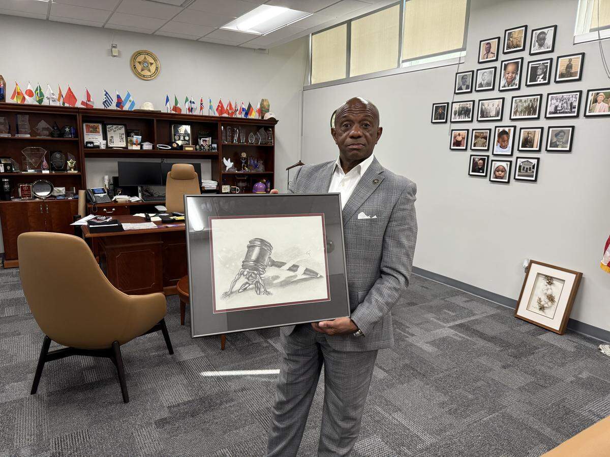 Sheriff Garry McFadden poses with artwork that one of the former residents at Jail North created. Jail North served as a juvenile detention center for years, and was considered successful. But McFadden closed it so he could move staff to the adult jail.