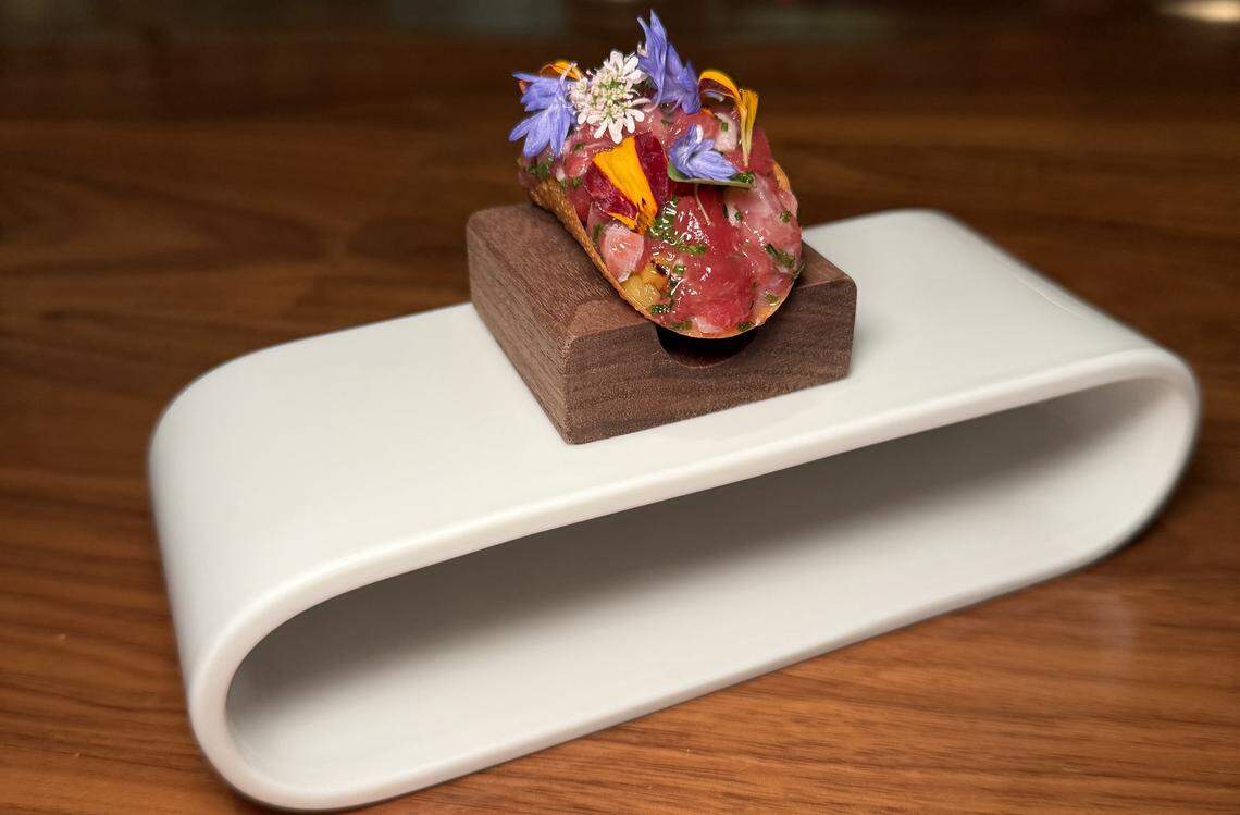 A bluefin tuna taco with winter flowers on a house-made potato chip from The Chef’s Table at Brooklyn Fare, a two Michelin Star restaurant in New York City.