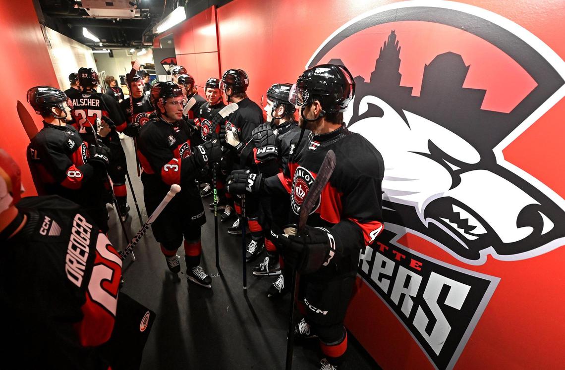 The Charlotte Checkers line a hallway at Bojangles Coliseum in Charlotte, NC prior to being introduced to fans on Friday, October 18, 2024. The Charlotte Checkers hosted the Cleveland Monsters in the home opener.